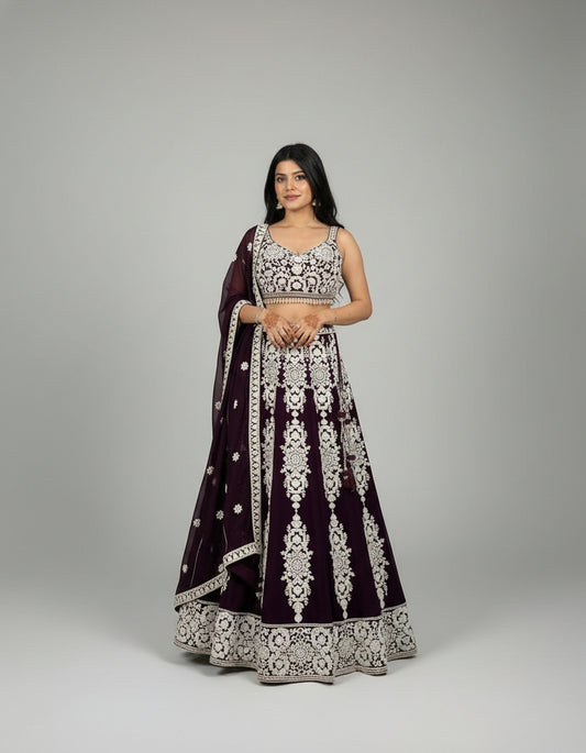 Woman in traditional outfit standing in front of floral decorations and a building.