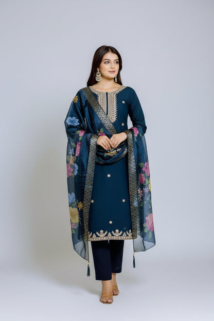 Woman in a navy blue traditional outfit with floral dupatta in an indoor setting