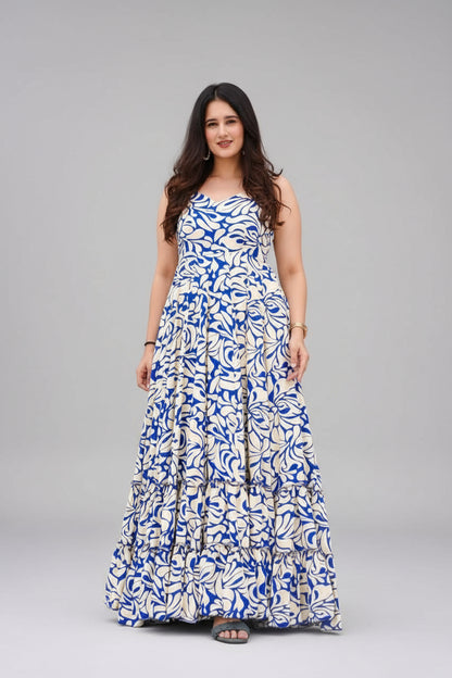 Woman wearing a blue and white patterned dress standing outdoors.