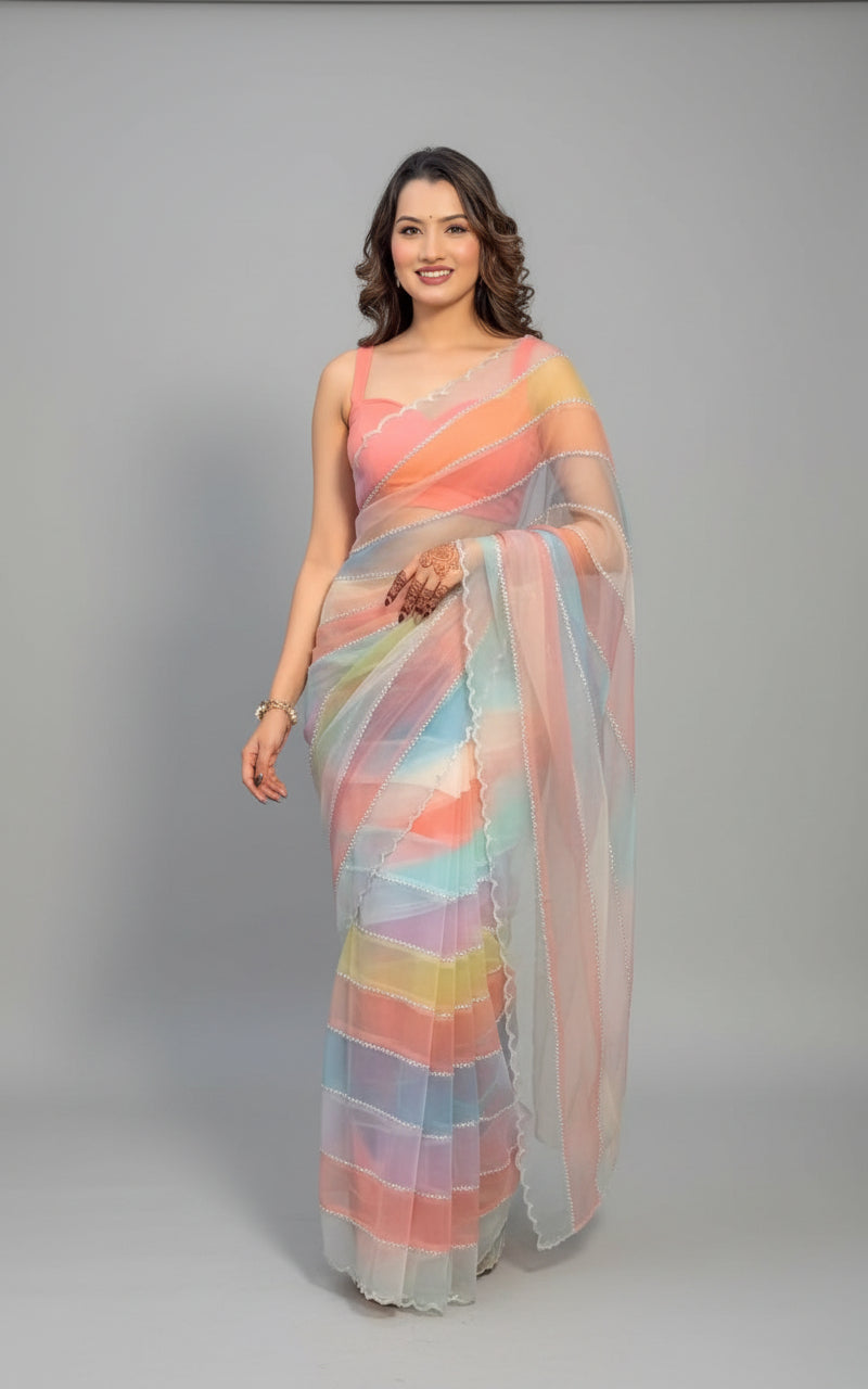 Woman in a colorful saree standing indoors with plants in the background