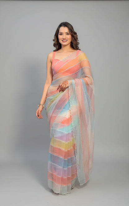 Woman in a colorful saree standing indoors with plants in the background