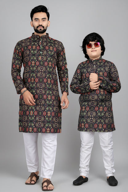 Two individuals wearing matching traditional outfits with a brown background and Vemmer logo.