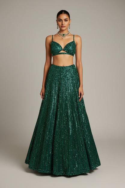 Woman in a green sequined outfit standing in an elegant interior setting.