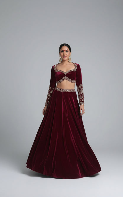 Woman in a maroon traditional outfit standing indoors.