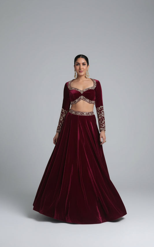 Woman in a maroon traditional outfit standing indoors.