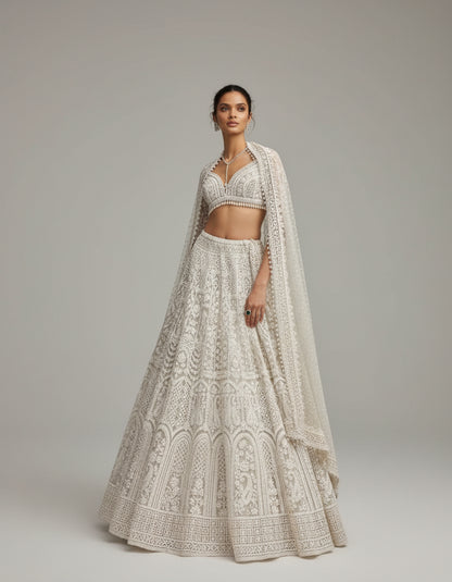 Woman in a white embroidered traditional outfit standing in front of a historic building.