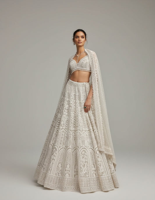 Woman in a white embroidered traditional outfit standing in front of a historic building.