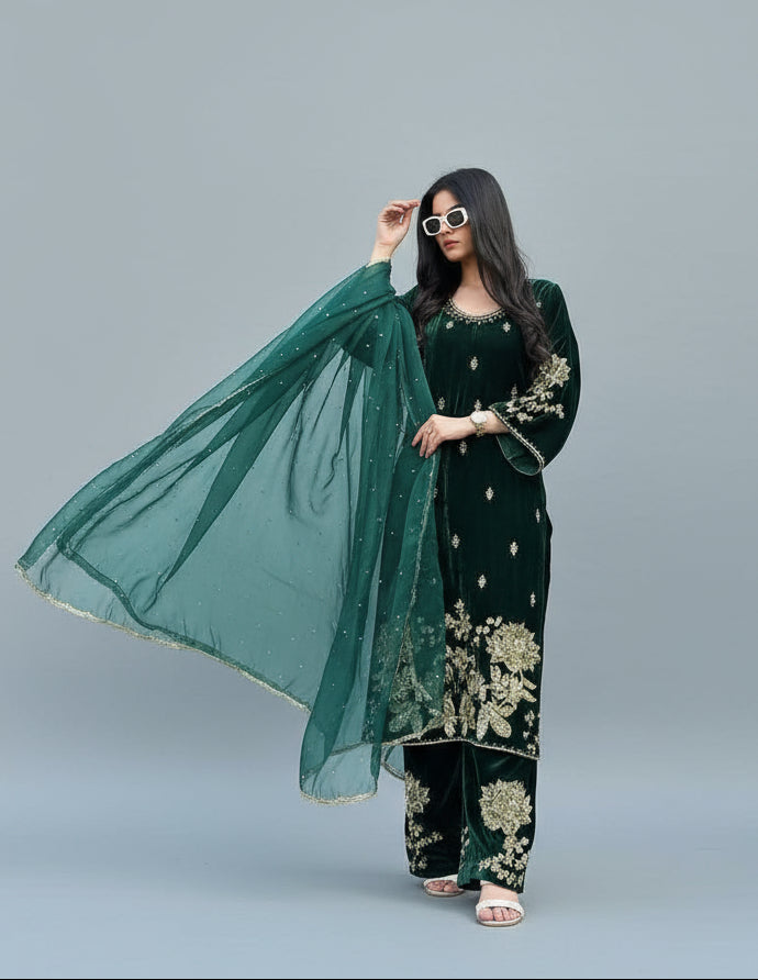 Woman in a green and black traditional outfit standing in front of a building.